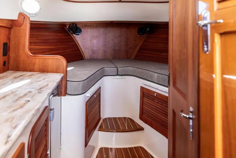 Slide: The Image of Interior of 2014 Hinckley Talaria 34 boat with wooden cabinetry and cushioned seating. - 14