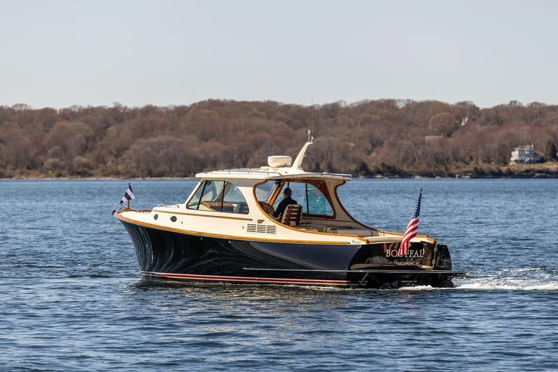 Slide: The Image of 2014 Hinckley Talaria 34 cruising on a serene lake with wooded shoreline. - 3