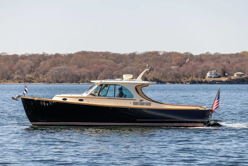 Slide: The Image of 2014 Hinckley Talaria 34 cruising on a calm lake with wooded shoreline backdrop. - 4