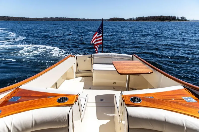 Slide: The Image of 2014 Hinckley Talaria 34 boat with American flag on open water. - 6