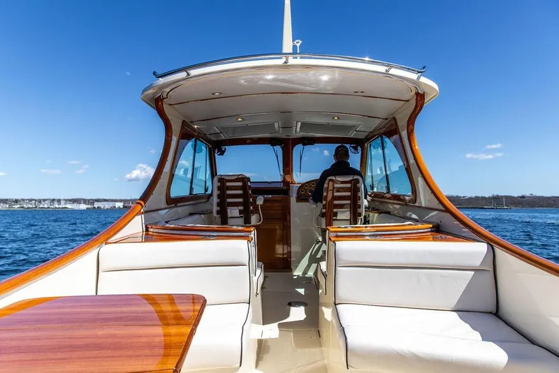 Slide: The Image of 2014 Hinckley Talaria 34 yacht interior with elegant seating and wooden accents on open water. - 7