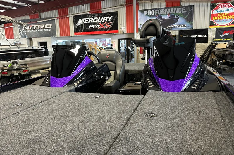Slide: The Image of 2026 Triton 20XP Patriot bass boat with purple accents in a showroom. - 22