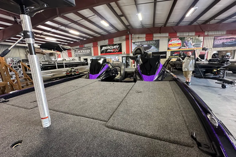 Slide: The Image of 2026 Triton 20XP Patriot boat displayed in a showroom with various other boats. - 21