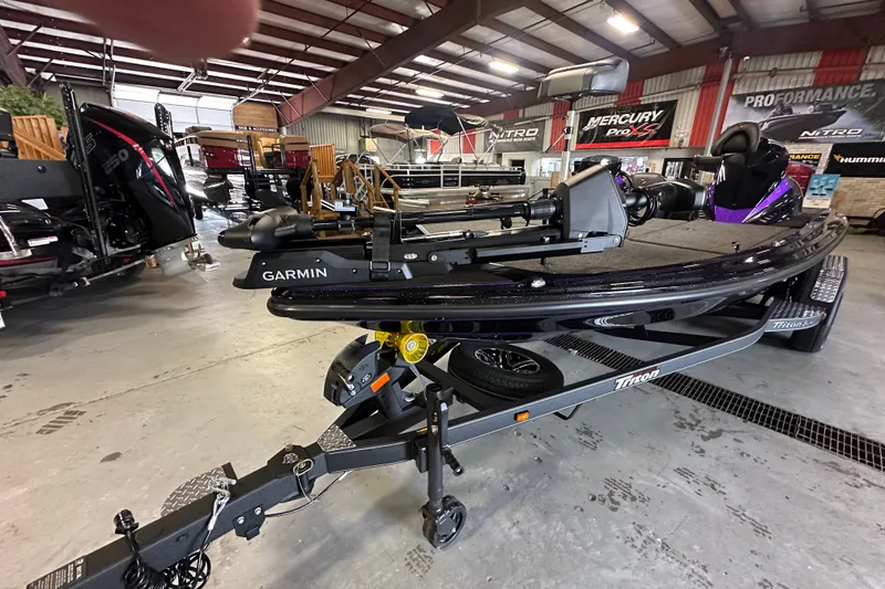 Slide: The Image of 2026 Triton 20XP Patriot boat in showroom, featuring Garmin equipment and sleek design. - 23