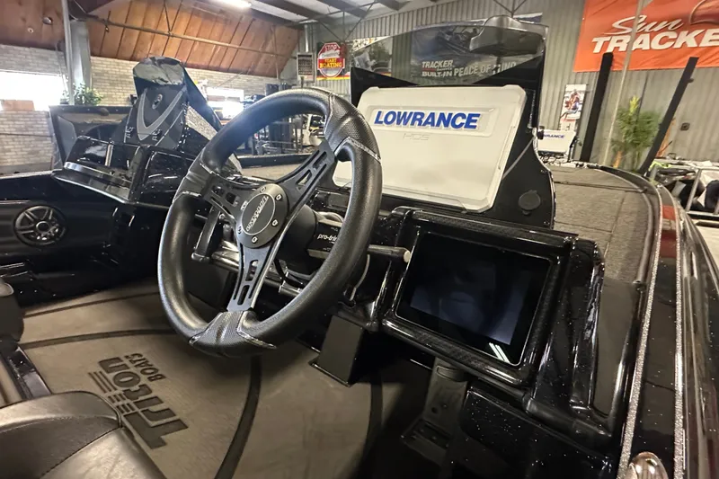 Slide: The Image of 2025 Triton 21XP Patriot boat interior with steering wheel and Lowrance navigation system. - 11