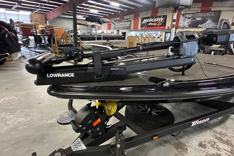 Slide: The Image of 2025 Triton 21XP Patriot boat with Lowrance equipment in showroom. - 19