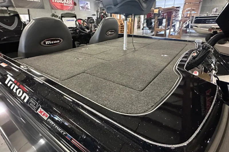 Slide: The Image of 2025 Triton 21XP Patriot boat interior with seating and carpeted deck. - 15