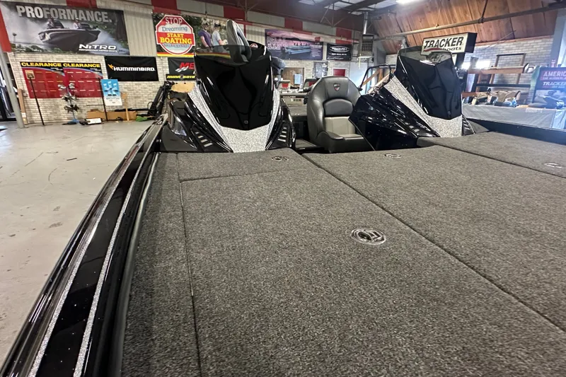 Slide: The Image of 2025 Triton 21XP Patriot boat interior with carpeted deck in showroom. - 9