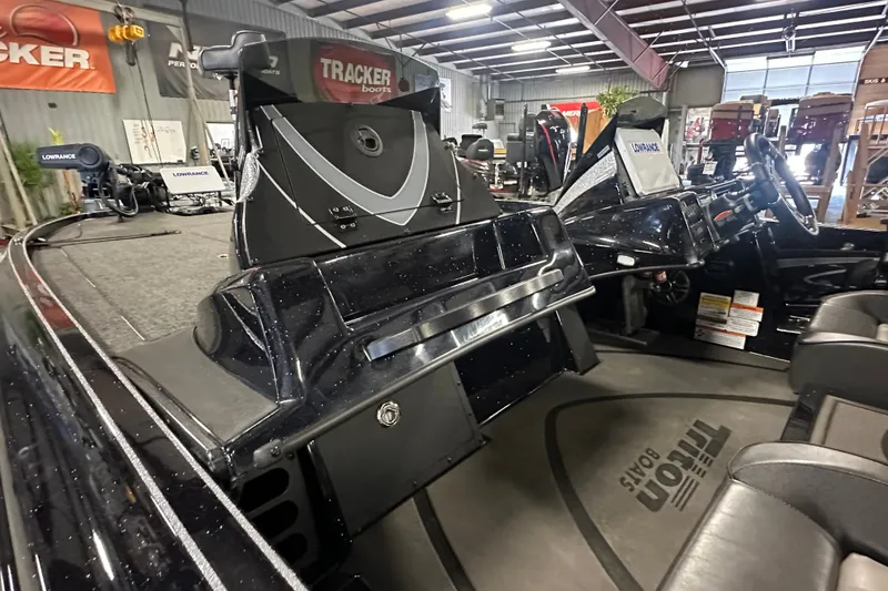 Slide: The Image of 2025 Triton 21XP Patriot boat interior with advanced dashboard and seating in showroom. - 16