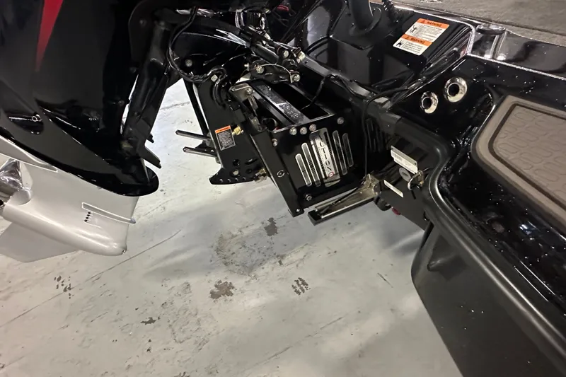 Slide: The Image of 2025 Triton 21XP Patriot boat engine and transom detail in a garage setting. - 13