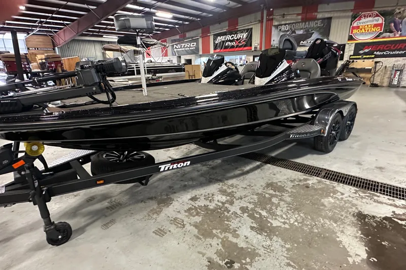 Slide: The Image of 2025 Triton 21XP Patriot boat in showroom, sleek black design on trailer. - 5