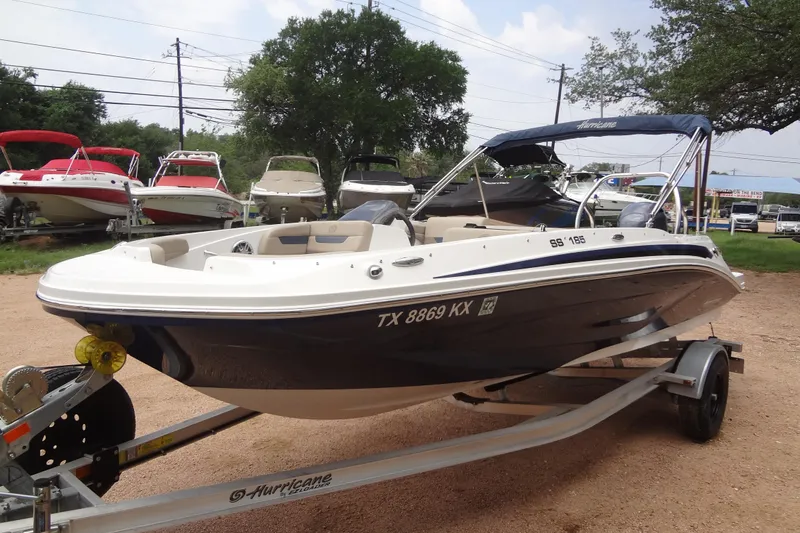 The Image of 2022 Hurricane SunDeck Sport 185 OB boat on trailer, surrounded by other boats. - 0