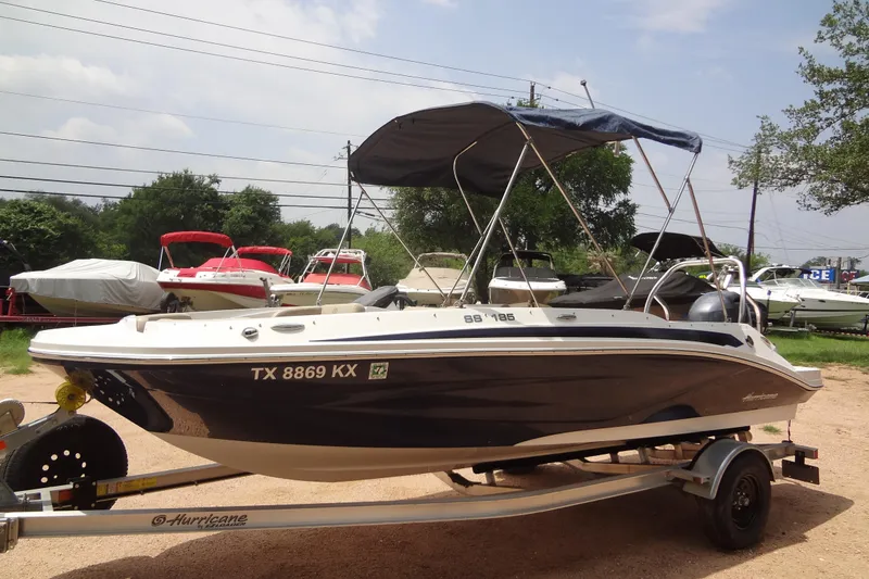 Slide: The Image of 2022 Hurricane SunDeck Sport 185 OB boat on trailer, parked outdoors. - 24