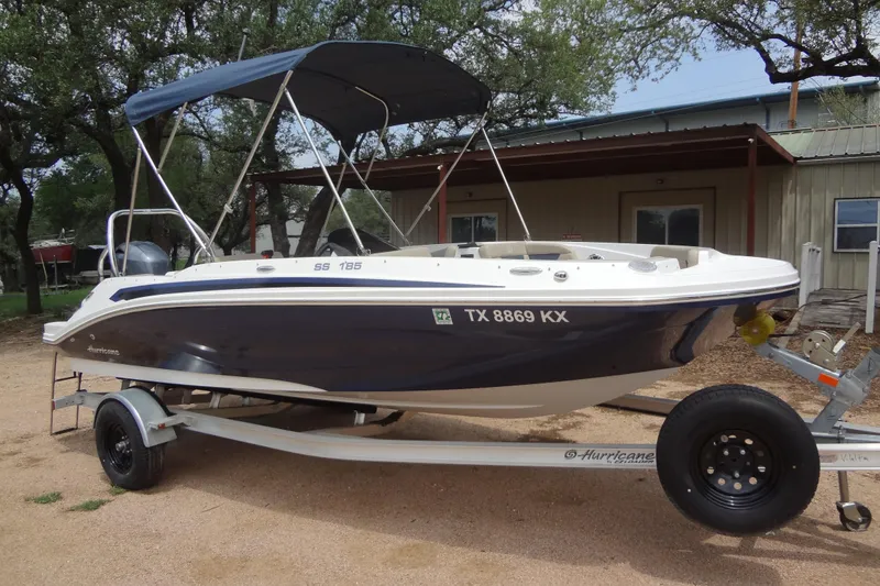 Slide: The Image of 2022 Hurricane SunDeck Sport 185 OB boat on trailer, parked outdoors. - 26