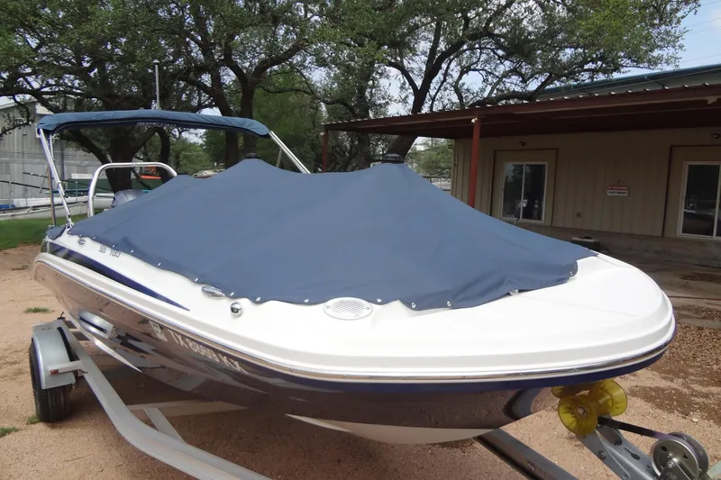 Slide: The Image of 2022 Hurricane SunDeck Sport 185 OB boat with cover, parked on trailer. - 27