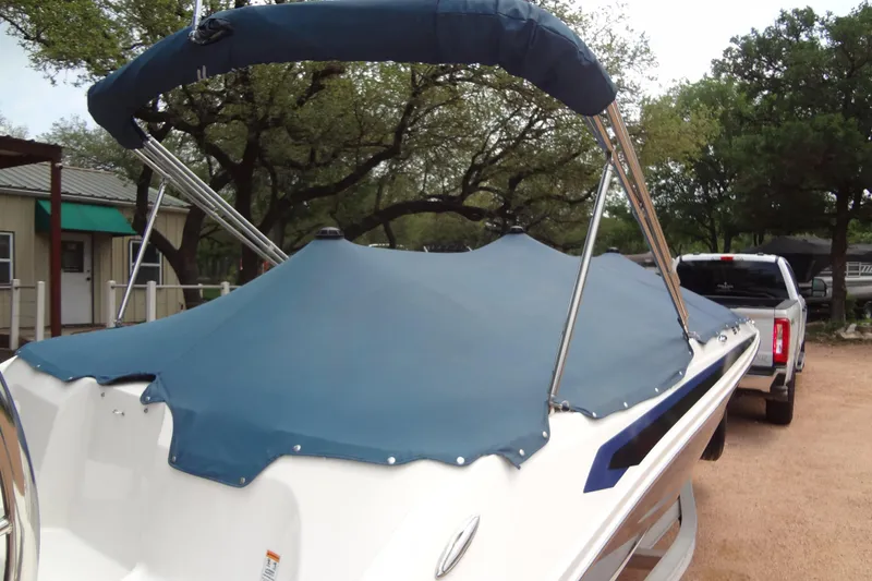 Slide: The Image of 2022 Hurricane SunDeck Sport 185 OB boat with blue cover, parked outdoors. - 28
