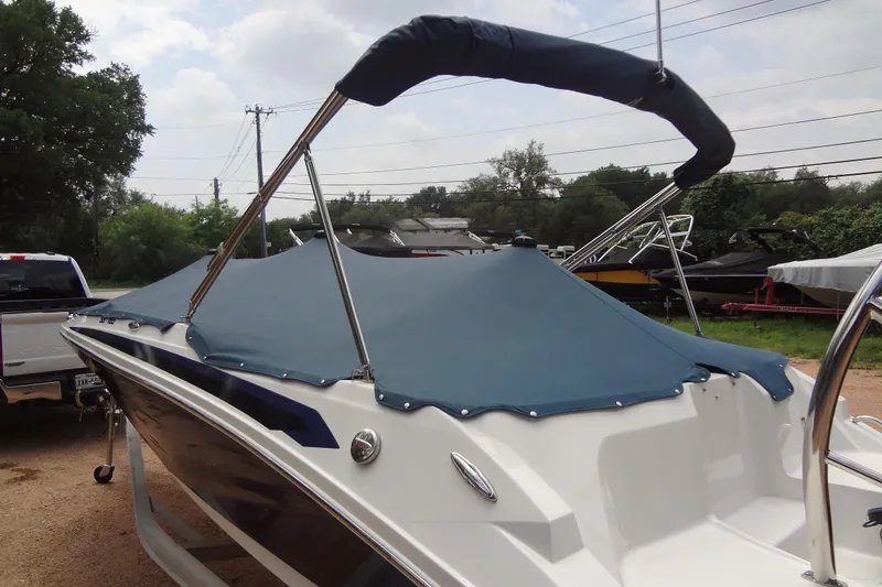 Slide: The Image of 2022 Hurricane SunDeck Sport 185 OB boat with blue cover and bimini top. - 29