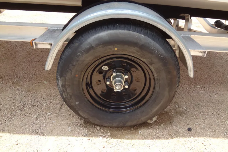 Slide: The Image of Trailer wheel of 2022 Hurricane SunDeck Sport 185 OB on gravel surface. - 36