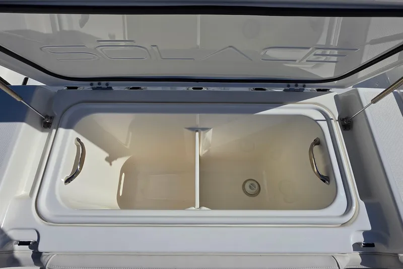 Slide: The Image of Open storage compartment on 2026 Solace 35CS boat, featuring sleek design and sturdy handles. - 27