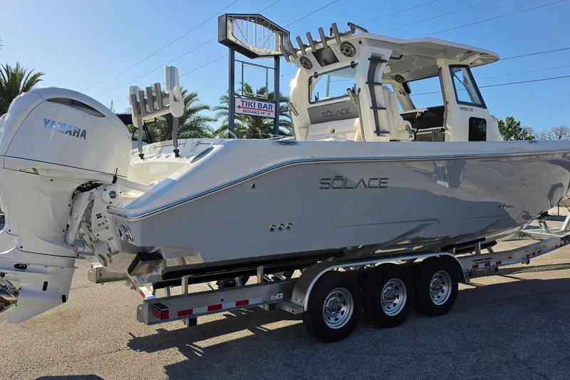 Slide: The Image of 2026 Solace 35CS boat on trailer with Yamaha engine, parked near Tiki Bar sign. - 6