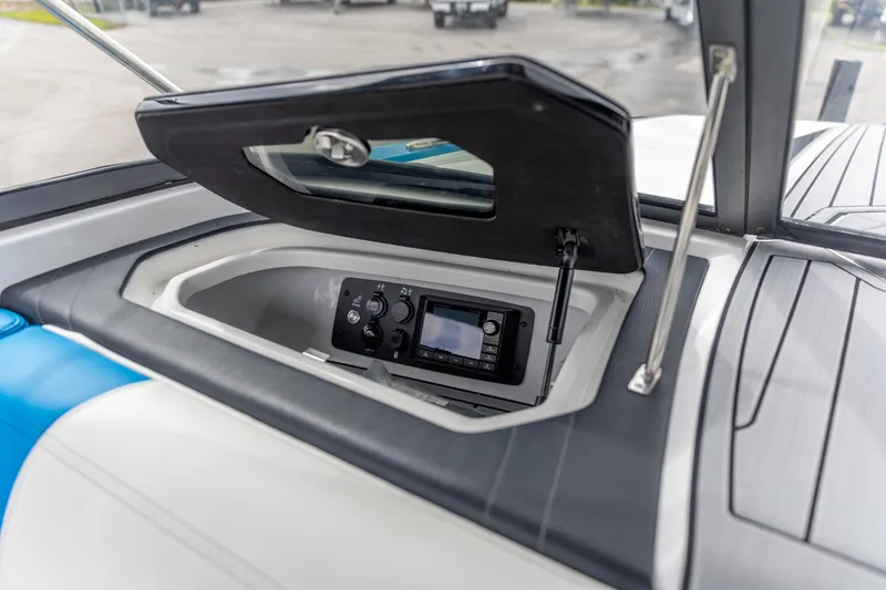 Slide: The Image of 2021 Nautique Ski Nautique boat dashboard with open storage compartment and control panel. - 10