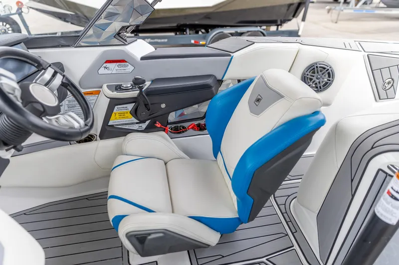 Slide: The Image of 2021 Nautique Ski Nautique interior with blue and white seating, steering wheel, and controls. - 11