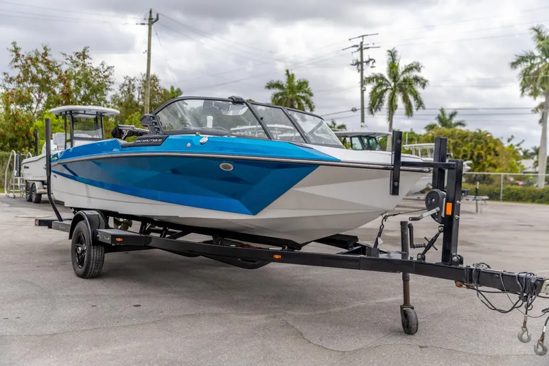 Slide: The Image of 2021 Nautique Ski Nautique boat on trailer, blue and white design, parked outdoors. - 17
