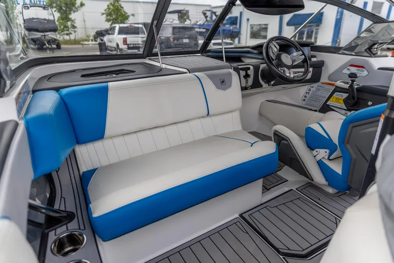 Slide: The Image of 2021 Nautique Ski Nautique interior with blue and white seating, modern dashboard, and steering wheel. - 2