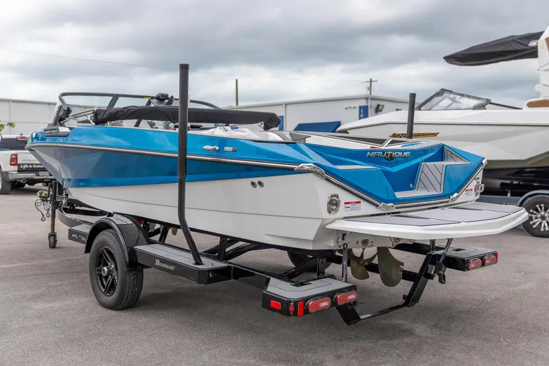 Slide: The Image of 2021 Nautique Ski Nautique boat on trailer, blue and white design, parked outdoors. - 5