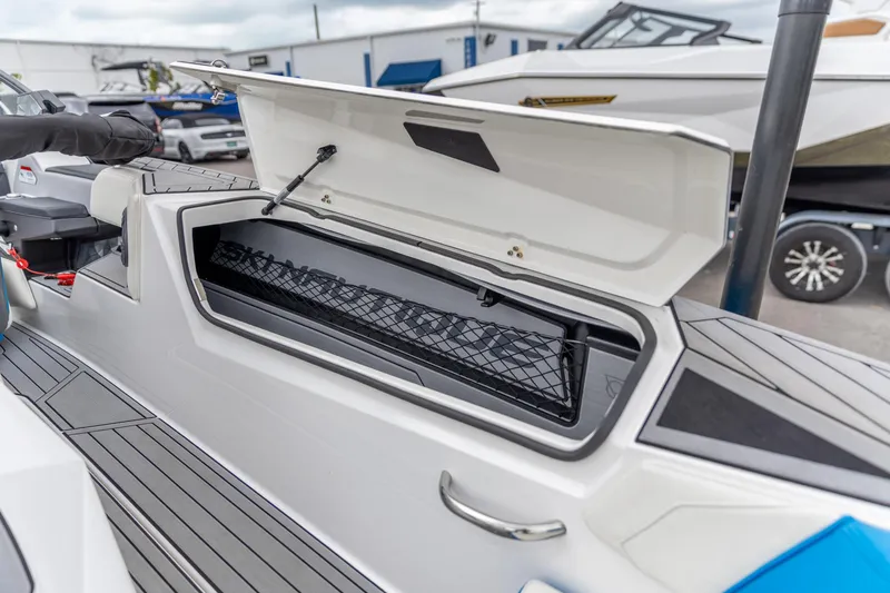 Slide: The Image of 2021 Nautique Ski Nautique boat with open storage compartment, showcasing sleek design. - 6