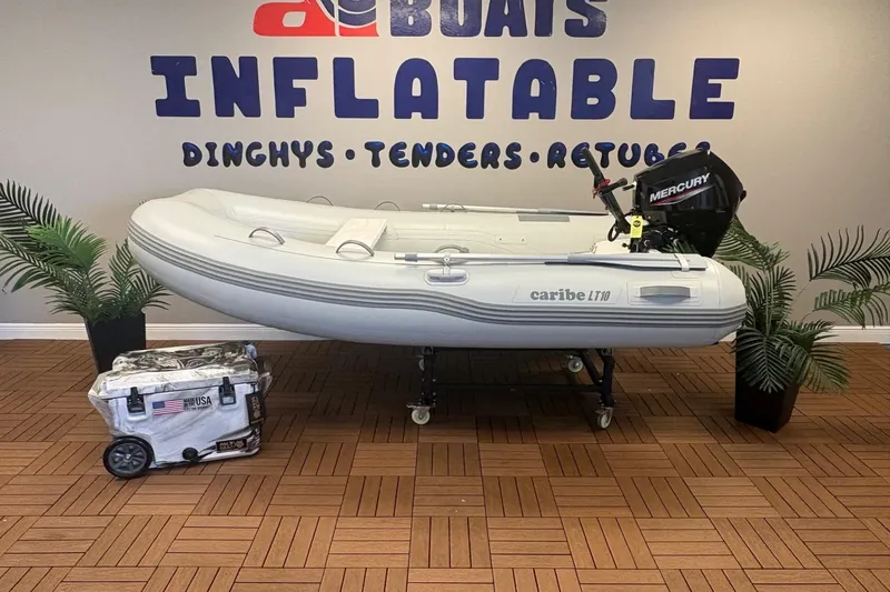 The Image of Inflatable Caribe L-10 boat with Mercury motor, displayed indoors with plants. - 0