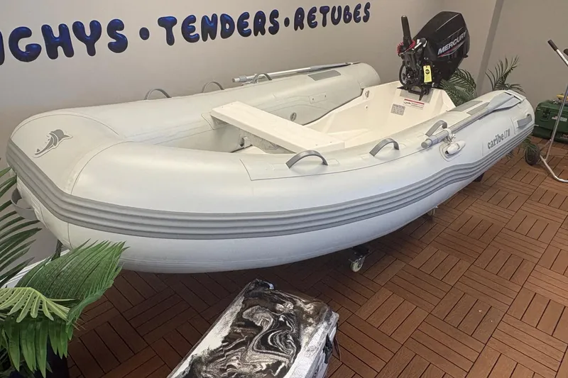 Slide: The Image of Inflatable Caribe L-10 boat, 2025 model, displayed indoors with Mercury outboard motor. - 4