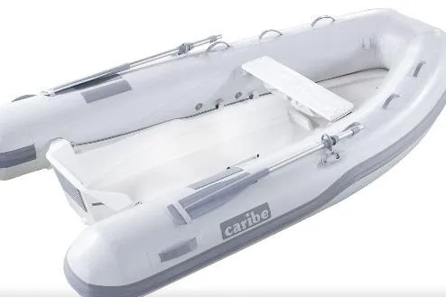 Slide: The Image of 2025 Caribe L-10 inflatable boat, white with gray accents, featuring oars and seating. - 5