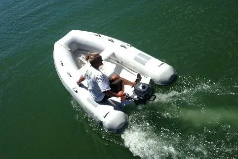Slide: The Image of Man operating a 2025 Caribe L-10 inflatable boat on open water. - 6