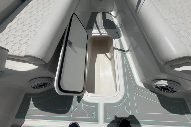 Slide: The Image of 2022 Glasstream 280 Pro-XS boat interior with open storage compartment and cushioned seating. - 13