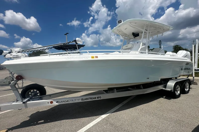 Slide: The Image of 2022 Glasstream 280 Pro-XS boat on trailer under a partly cloudy sky. - 2