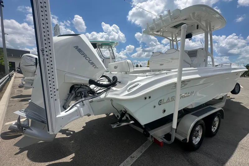 Slide: The Image of 2022 Glasstream 280 Pro-XS boat with Mercury engine, parked on a trailer under a sunny sky. - 4