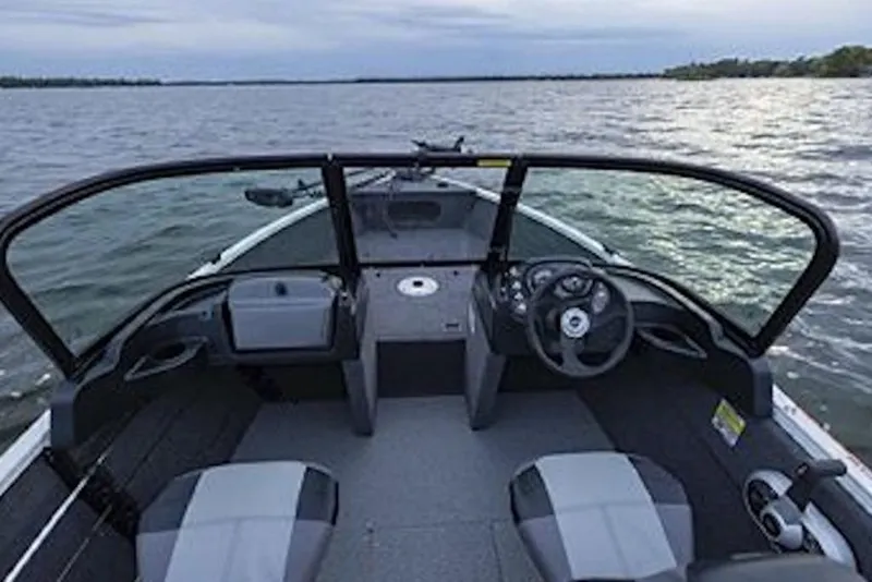Slide: The Image of 2027 Crestliner 1650 Kodiak WT boat interior with dual seats and steering wheel on a lake. - 66