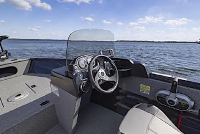 Slide: The Image of 2027 Crestliner 1650 Kodiak WT boat interior with steering wheel, dashboard, and lake view. - 67