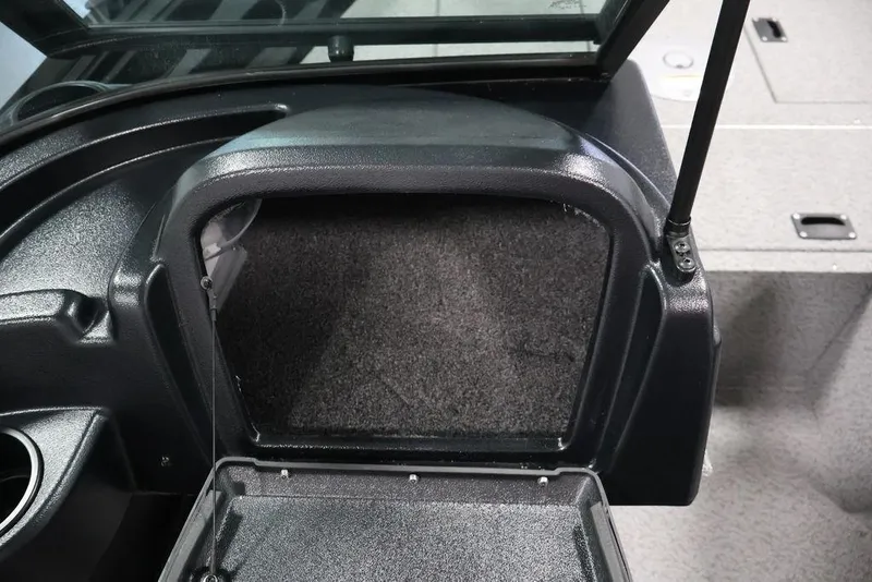 Slide: The Image of 2027 Crestliner 1650 Kodiak WT boat storage compartment with open hatch and carpeted interior. - 47