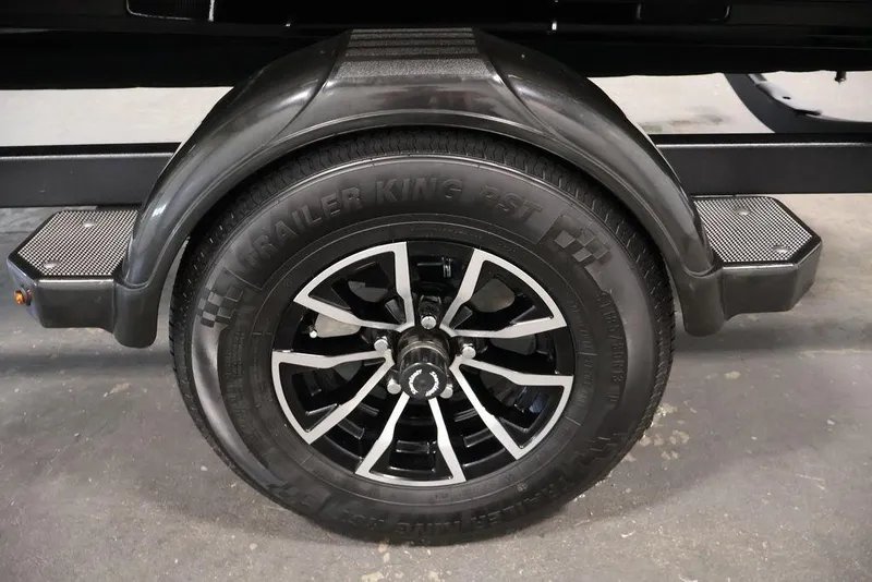 Slide: The Image of 2027 Crestliner 1650 Kodiak WT trailer wheel with black alloy rim and tire. - 60