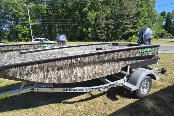 The Image of 2026 Havoc 1553 VJST boat on trailer, camo design, parked outdoors. - 0