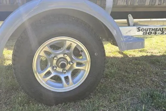 Slide: The Image of Trailer wheel of a 2026 Havoc 1553 VJST on grassy ground. - 12