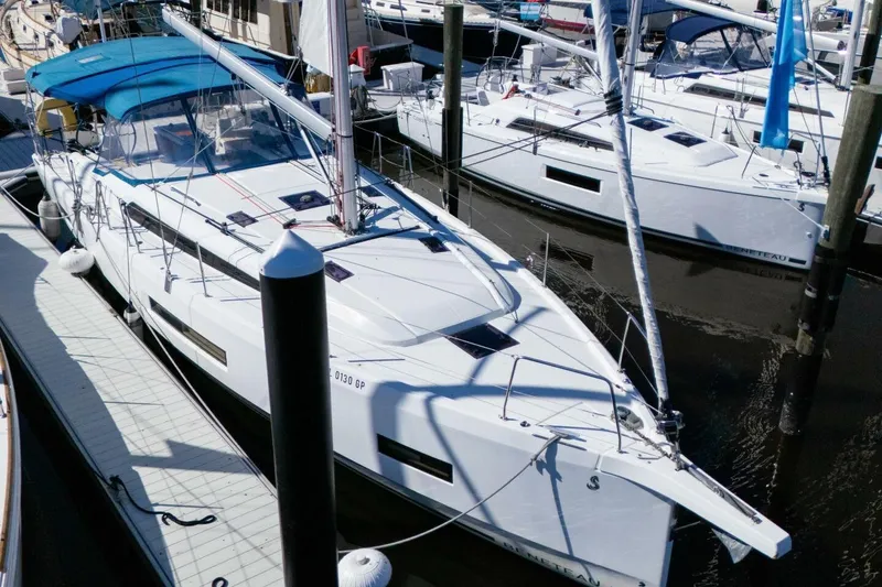 Slide: The Image of 2022 Beneteau Oceanis 40.1 sailboat docked at marina, featuring sleek design and blue canopy. - 106