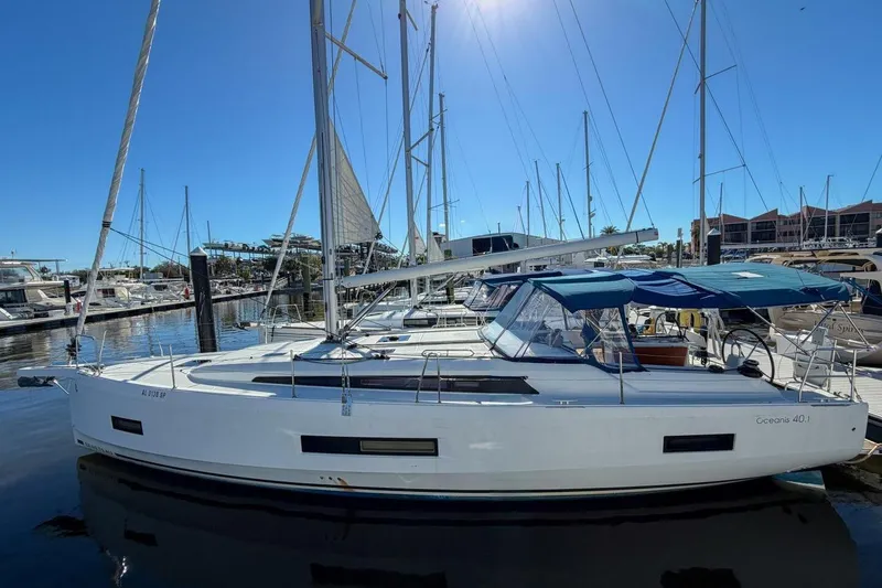 Slide: The Image of 2022 Beneteau Oceanis 40.1 sailboat docked in a marina under clear blue skies. - 115