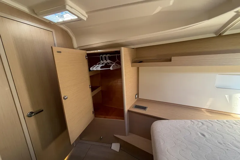 Slide: The Image of Interior of 2022 Beneteau Oceanis 40.1 yacht with open closet and bed. - 12