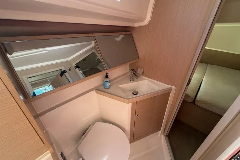 Slide: The Image of Beneteau Oceanis 40.1 2022 yacht bathroom with sink, mirror, and adjacent cabin. - 17