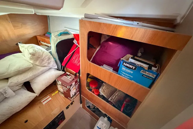 Slide: The Image of Cozy cabin storage in 2022 Beneteau Oceanis 40.1 sailboat, featuring pillows and organized supplies. - 24