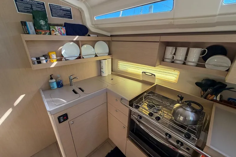 Slide: The Image of Modern kitchen in 2022 Beneteau Oceanis 40.1 yacht, featuring stove, sink, and storage. - 32