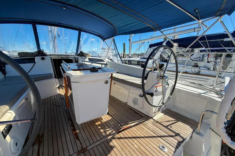Slide: The Image of 2022 Beneteau Oceanis 40.1 yacht cockpit with dual steering wheels and teak flooring. - 57